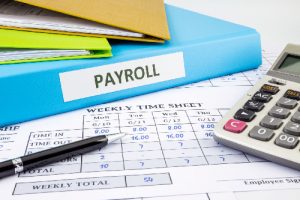 Binder labeled PAYROLL next to Time Card and Calculator