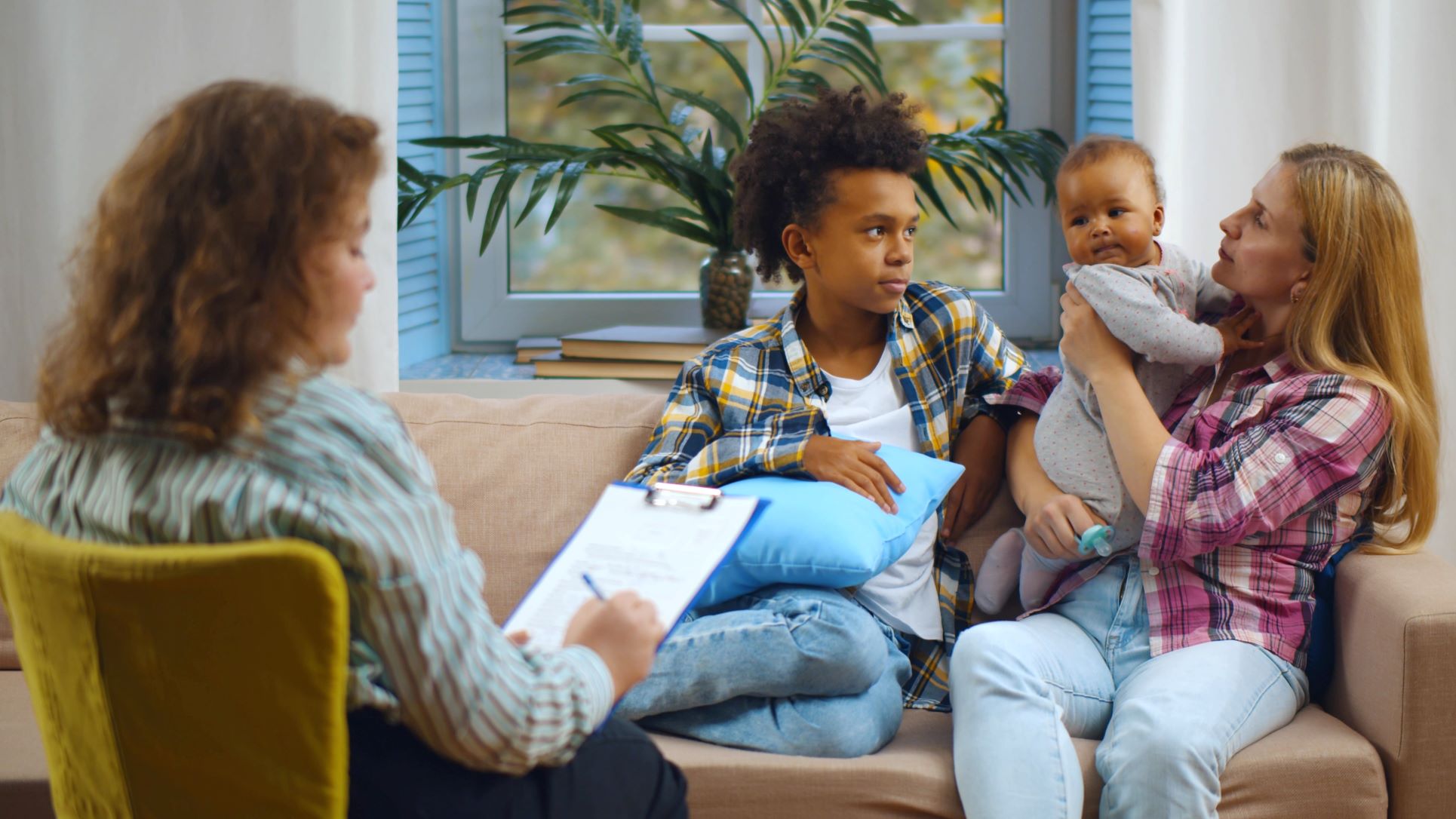 Case worker sitting with young teen, baby, and woman